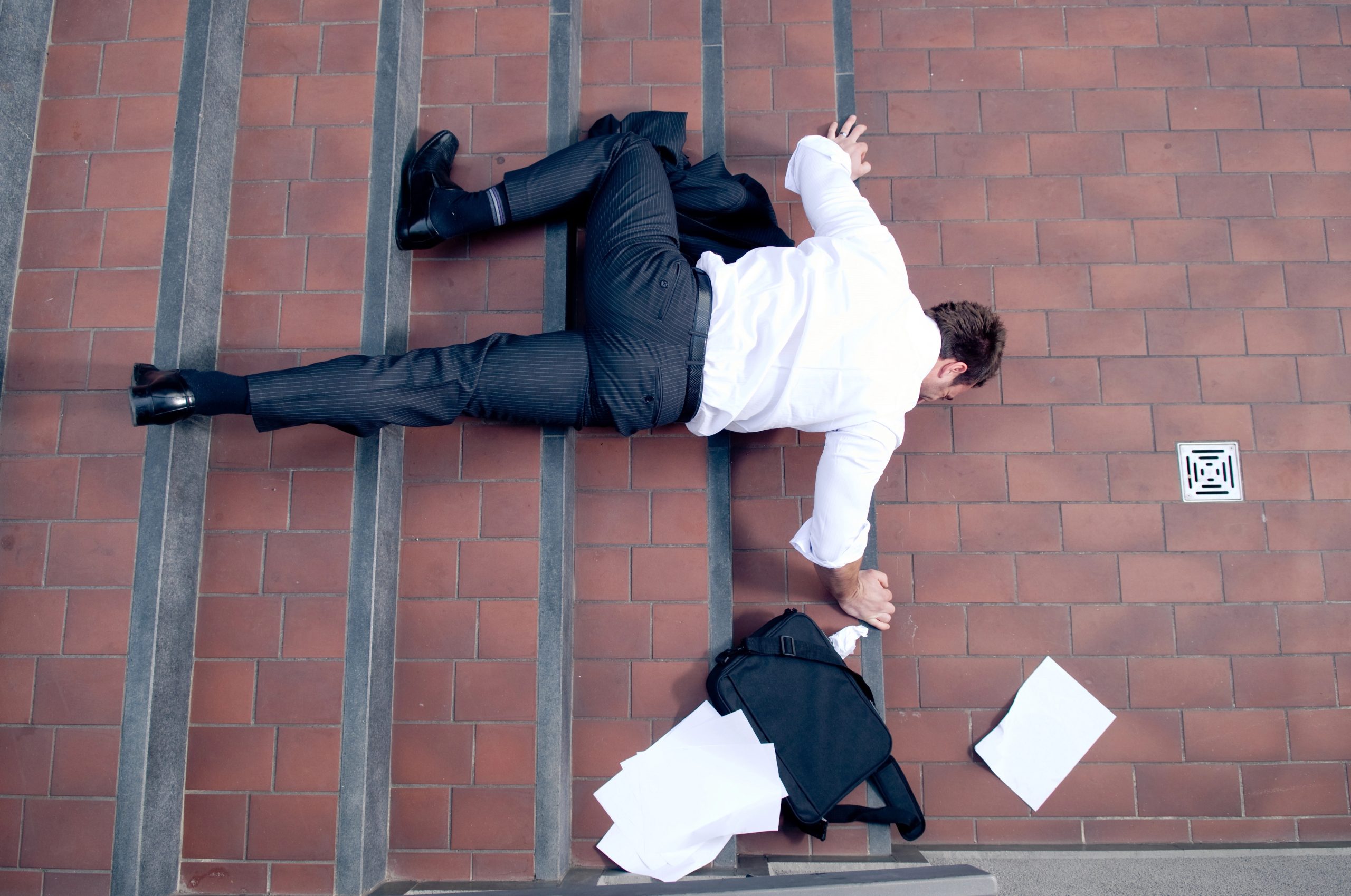 Depositphotos_8342902_XL - Warshafsky Law Firm Milwaukee, Wisconsin - Warshafsky Law Firm Milwaukee, Wisconsin Top-down view of a man in a pinstripe suit and white shirt lying on red brick stairs with scattered papers and a black briefcase nearby. Warshafsky Law Firm Milwaukee, Wisconsin Warshafsky Law Firm Milwaukee, Wisconsin
